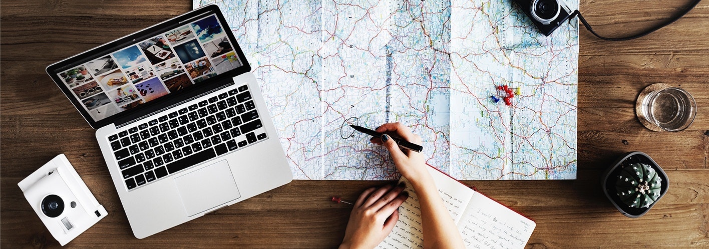 individual marking locations on a map spread out across a table